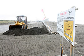 白子町の中里海岸では、駐車場にたまった砂やごみの撤去作業が行われた＝２７日