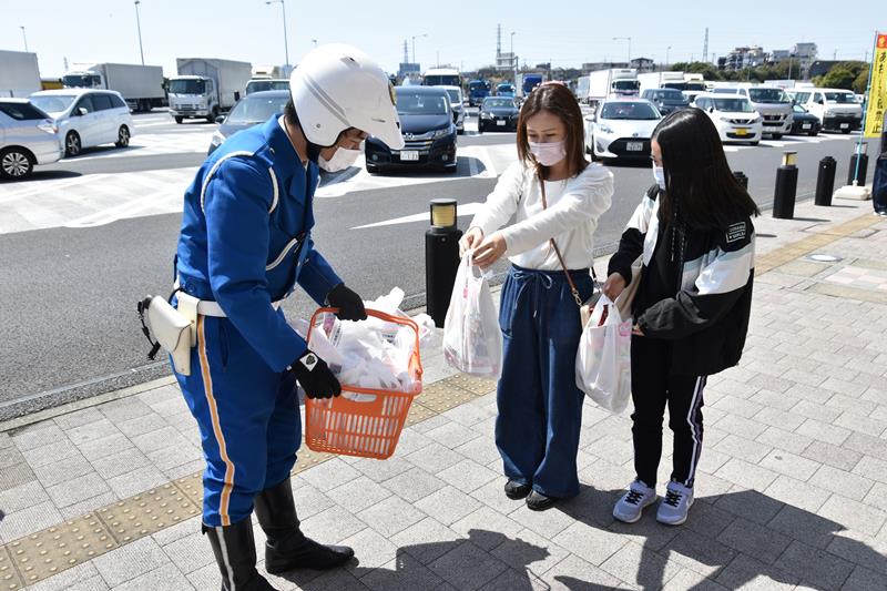 幕張ＰＡ利用者に交通安全啓発グッズを配る千葉県警高速隊員＝千葉市花見川区