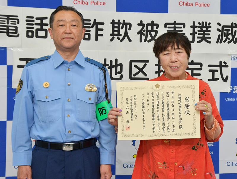 石山署長（左）から感謝状を受け取った神崎町四季の丘地区自治会長の鹿嶋さん＝香取署