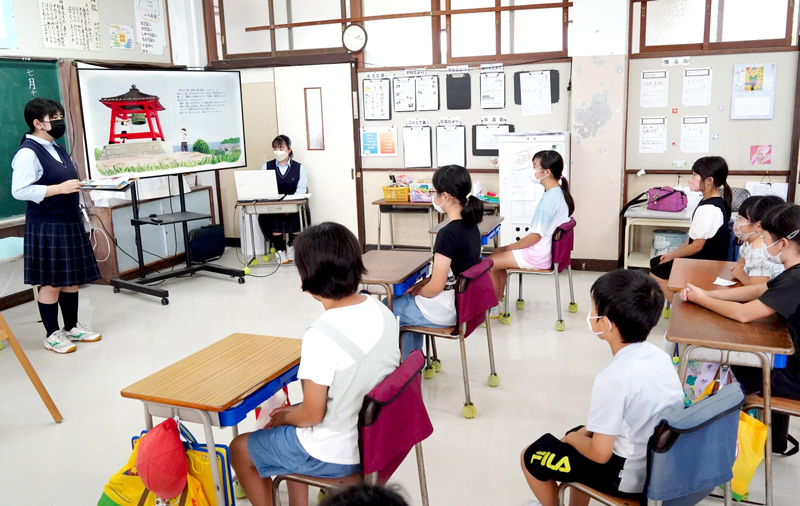 小学生へ平和の鐘について話す大原高生（左）＝いすみ市立東小
