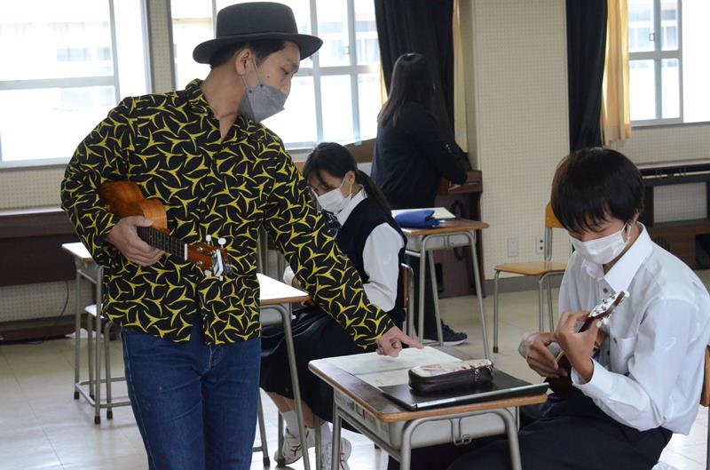 九十九里高の音楽の授業で生徒にウクレレの奏法を教える中村さん（左）＝九十九里町