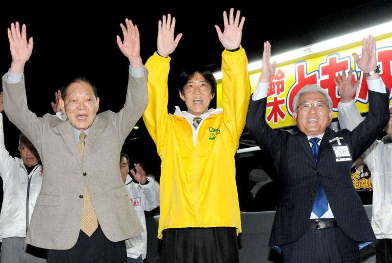 県議選市原市選挙区で初当選した自民党新人の鈴木友成氏（中央）は、引退する父・昌俊氏（左）と喜びを分かち合った。右は小出譲治市長＝９日午後１０時４５分ごろ、市原市の事務所