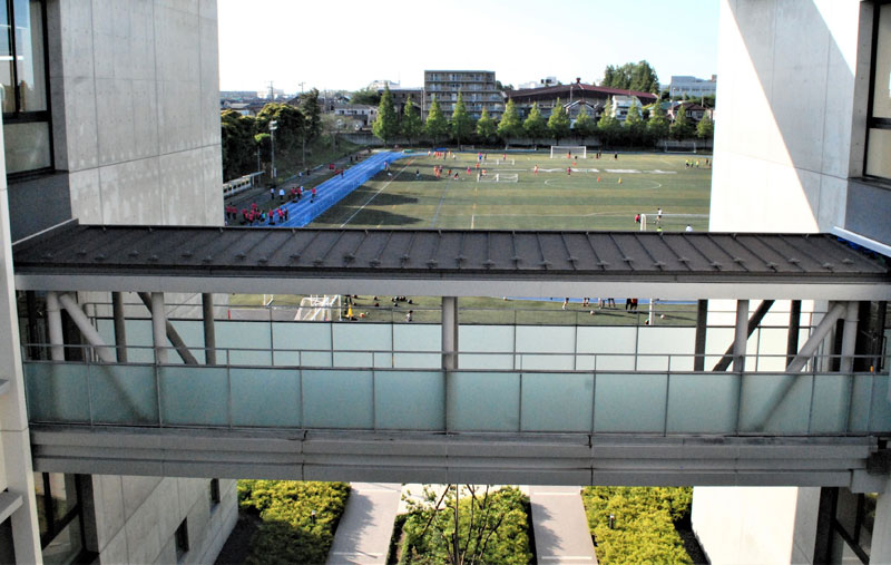 中学校棟(左)と高校棟の回廊から望むグラウンド。学校敷地全体は約8万5千平方メートルの広さ
