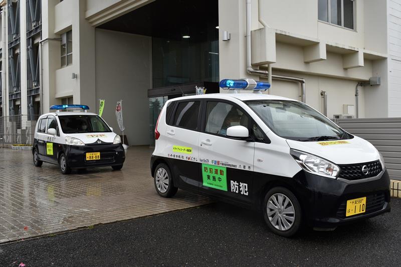 青色の回転灯をつけて通学路のパトロールに向かう巡回車=2日、八街市役所