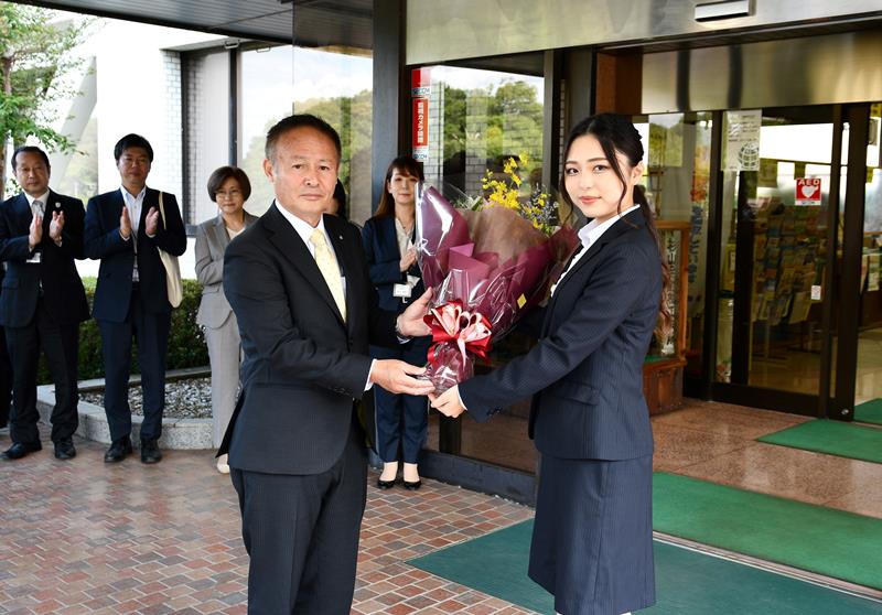 職員から花束を受け取る椿町長（左）＝２１日、神崎町役場