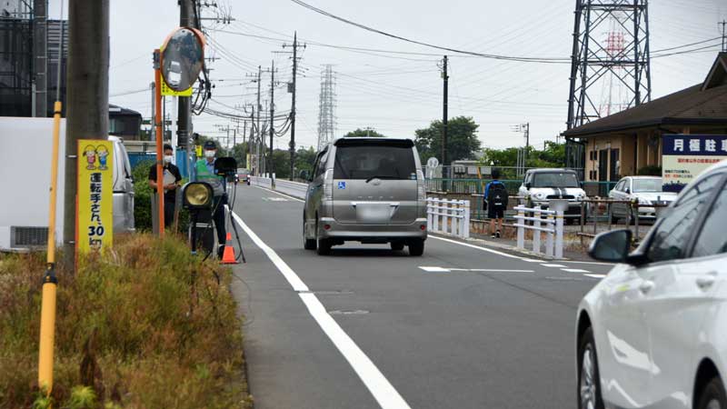事故現場付近で可搬式オービスを使い取り締まりをする警察官＝午前７時３５分ごろ、八街市（画像一部加工）
