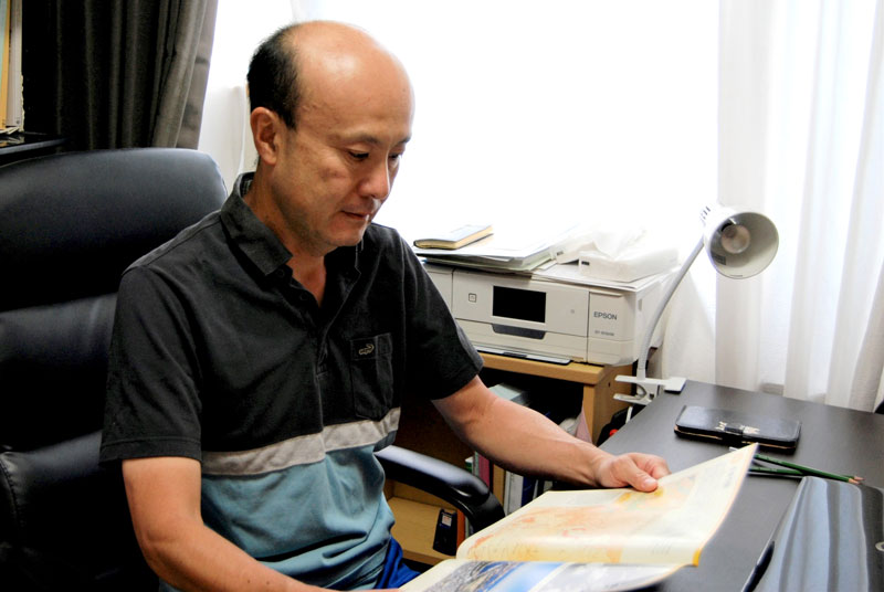 千葉空襲の資料に目を通す増田さん＝千葉市中央区