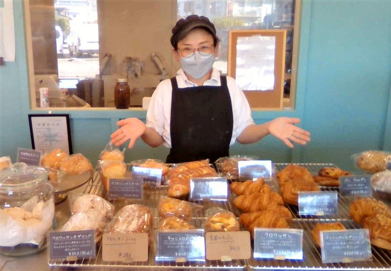 店内で焼きたてのパンを見せる永野さん