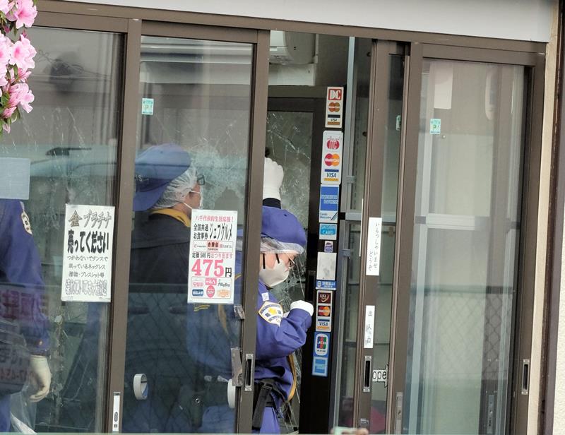 強盗事件のあった質店で鑑識作業を行う警察官ら＝２５日午後、八千代市八千代台南１