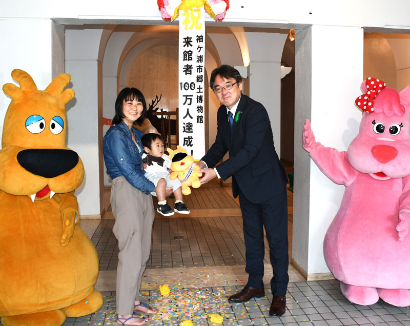 袖ケ浦市郷土博物館で１００万人目の入館者として迎えられた根本さん親子（市提供）