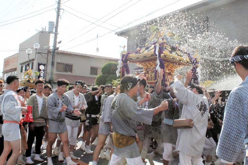 沿道からの水を浴びながら元気にみこしを揺らす担ぎ手ら＝４日、匝瑳市