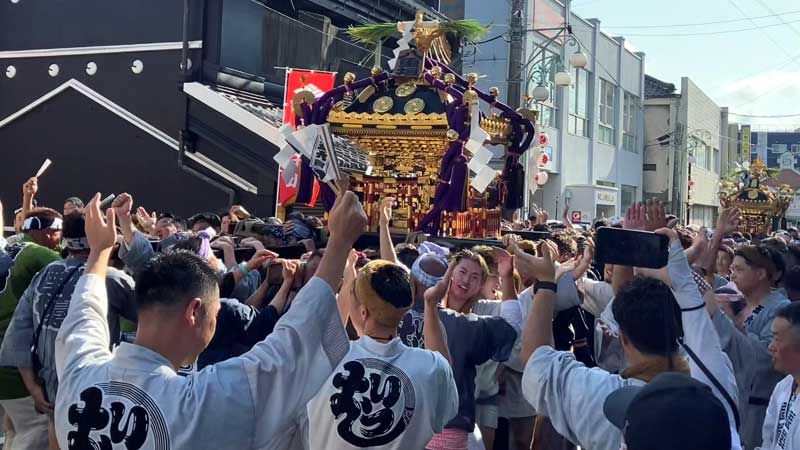 宮出し巡行で商店街にかけ声を響かせる担ぎ手ら＝４日、匝瑳市