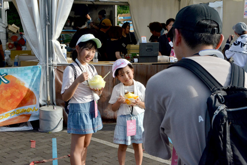 屋台でかき氷を購入してフェスを満喫する参加者たち