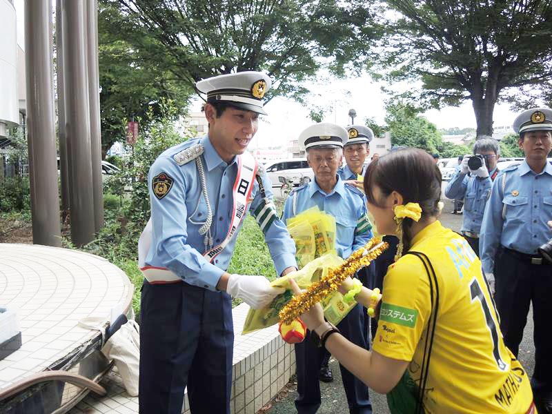一日警察署長に委嘱された柏レイソルGKの松本選手が、買い物客らに交通安全の啓発グッズを手渡した=野田市
