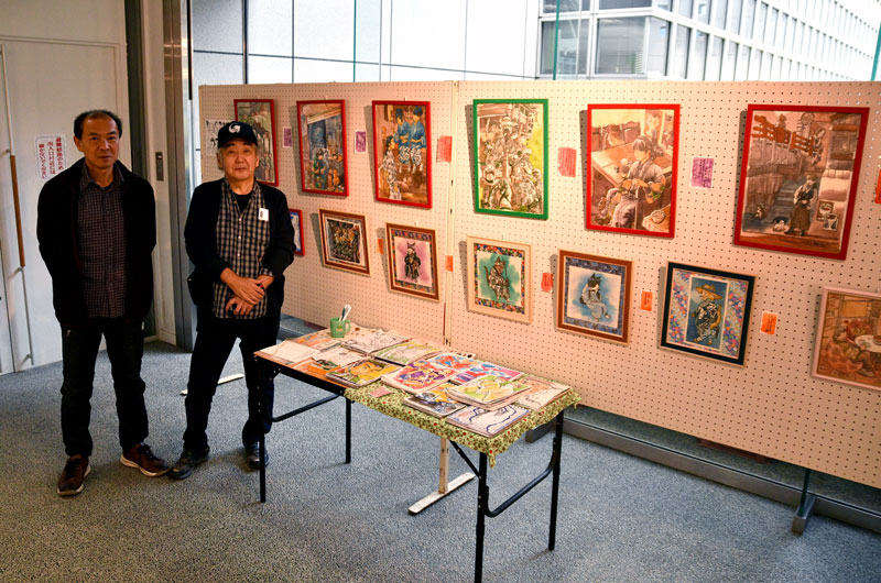 猫を題材にした作品がずらりと並ぶ「ネッコワーク展」を主催した川口さん（左）と八本さん＝２３日、香取市