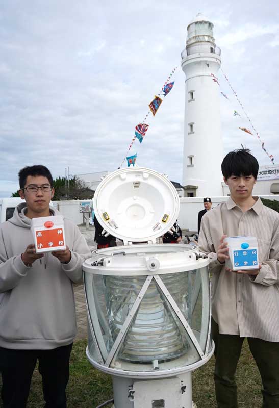 １０年前の１４０周年イベントでタイムカプセルに見立てた灯器に封入したメッセージを手にする高神小出身の代表２人＝１６日、銚子市