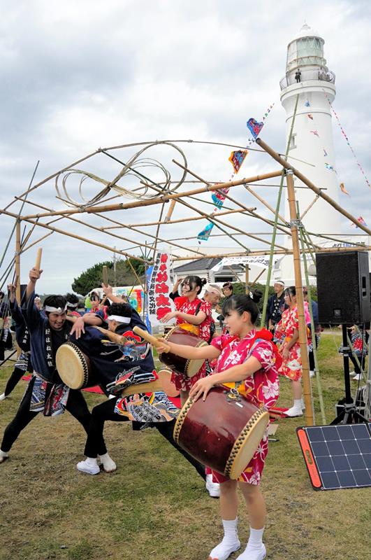 １５０周年の犬吠埼灯台の下で演奏を披露する郷土芸能の「銚子はね太鼓保存会」＝１６日、銚子市