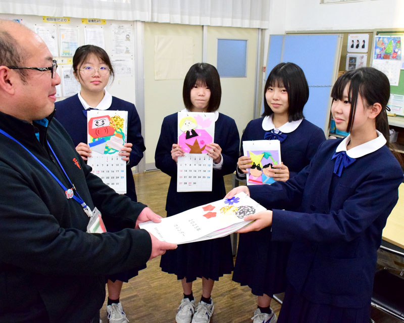 手作りカレンダーを社会福祉協議会の職員に渡す生徒＝茂原市立東中学校