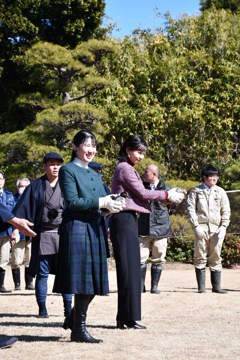捕獲されたカモを放そうとする愛子さま（左）と佳子さま（右隣り）＝１４日、市川市