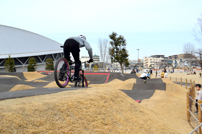 千葉公園内に設置されたトラックでスケートボードや競技用自転車を楽しむ子どもたち