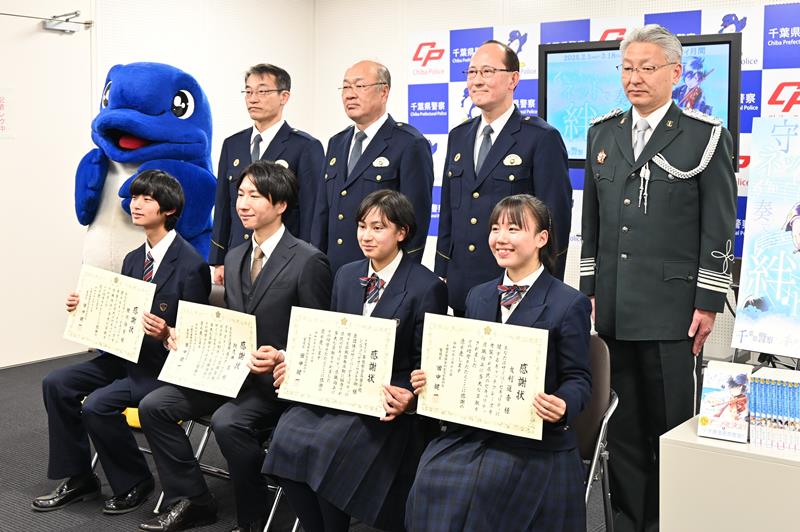 ポスター作成に協力した幕張総合高の生徒（前列）と作者の阿久井さんに感謝状が贈られた＝千葉県警本部