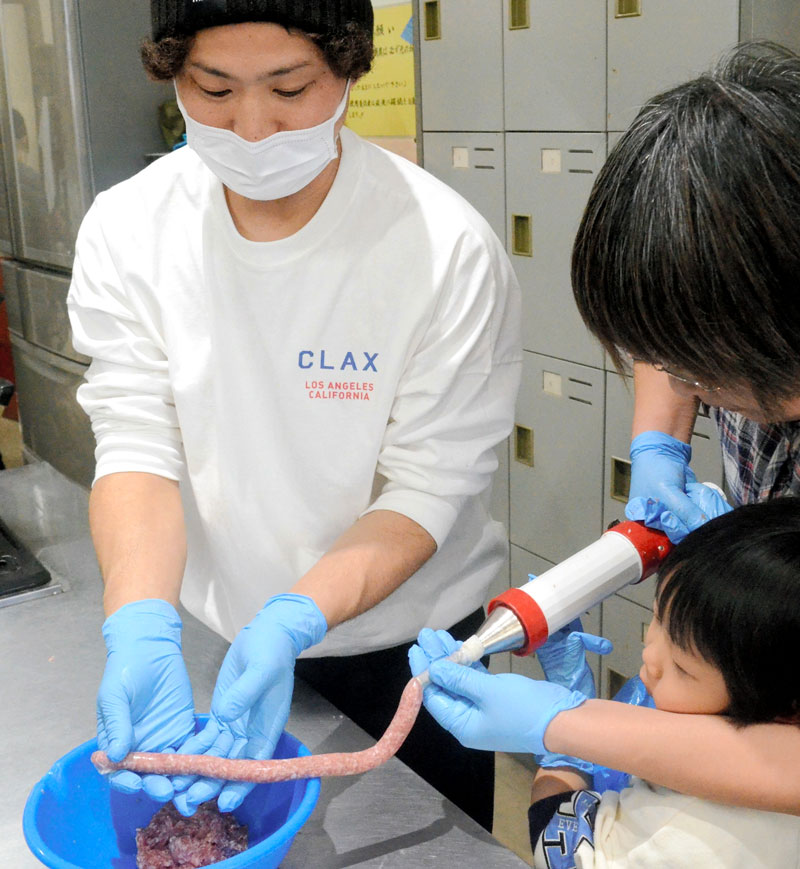 横芝光町名物の「大木式ソーセージ」作りを体験する児童や保護者ら＝横芝光町