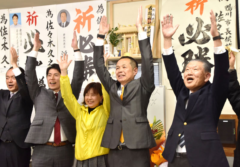 長谷川前市長（右）らと共に万歳三唱して当選を喜ぶ佐々木氏（右から２人目）＝１６日深夜、鴨川市
