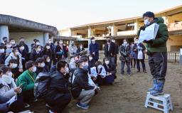 　被災した宮城県石巻市立大川小の校舎前で、高校生らに講話する佐藤敏郎さん（右端）＝８日午後