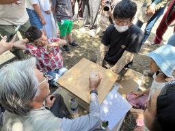　伝統行事「日本三大くも合戦」で土俵を囲む参加者と観戦者＝４日午後、千葉県富津市