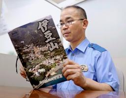 　静岡県警熱海署が大規模土石流に関わった署員の思いをまとめた文集「伊豆山」を読む同署幹部＝１６日