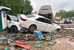　記録的な豪雨の影響で重なり合った車＝１日、北京市西部の門頭溝地区（共同）