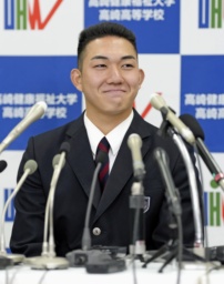 ロッテから１位指名を受け、笑顔で記者会見する健大高崎高の石垣元気投手＝２３日、群馬県高崎市