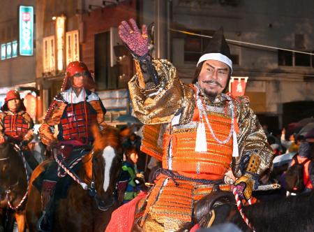 <p>　沿道の歓声に応える武田信玄役を務めた市川右団次さん（手前）＝４日夜、甲府市</p>
