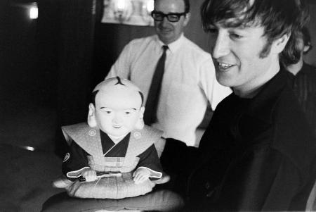 <p>　福助人形を手にほほ笑む英ロックバンド「ビートルズ」のジョン・レノンさん。１９６６年の来日公演で撮影された写真１０２枚分のネガフィルムが見つかった（日本武道館提供）</p>