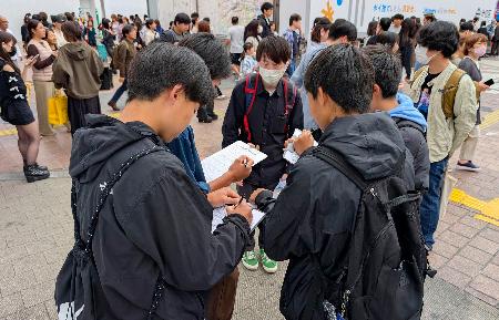 <p>　市民団体「日本平和委員会」が実施した、憲法に関するアンケートに答える若者たち＝３日午後、東京・渋谷</p>