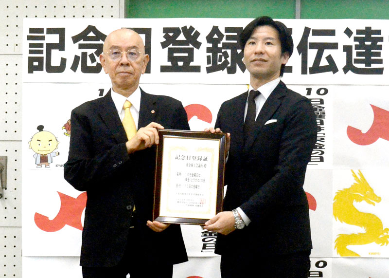 記念日「東金（とうがね）の日」の登録証を手にする東金商工会議所の前嶋会頭（左）と、日本記念日協会の田宮事務局長＝東金市