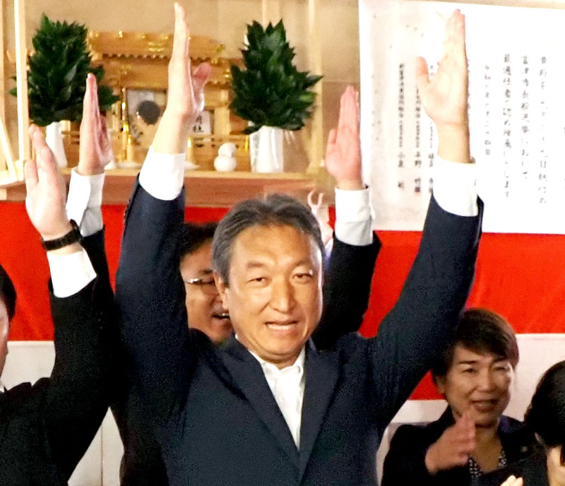３選を果たし、万歳をする高橋氏＝２９日夜、富津市