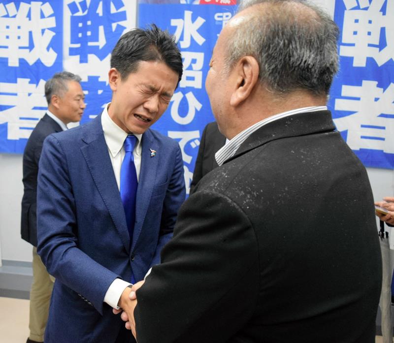 初当選を決め、支持者と握手する水沼氏＝２７日、船橋市