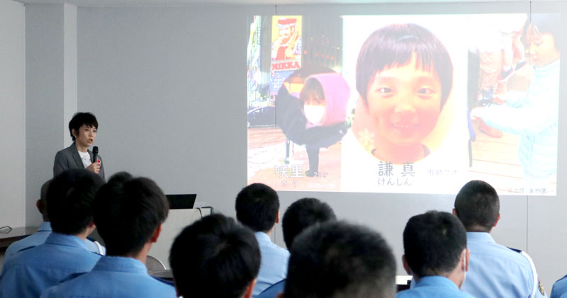 スクリーンに映し出された謙真君の写真の前で講演する高田さん＝１５日、千葉市中央区の県警本部交通合同庁舎