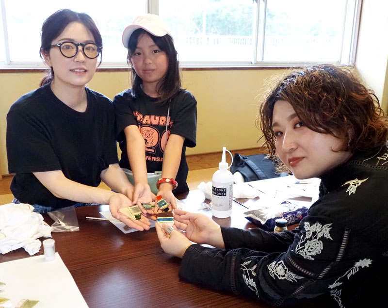 大貫仁美さん（右）のワークショップに参加し、完成したブローチを手にする親子＝君津市