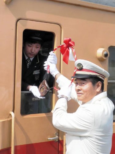 最終日セレモニーでタブレットを渡す長谷川駅長（右）＝１６日、ＪＲ久留里駅