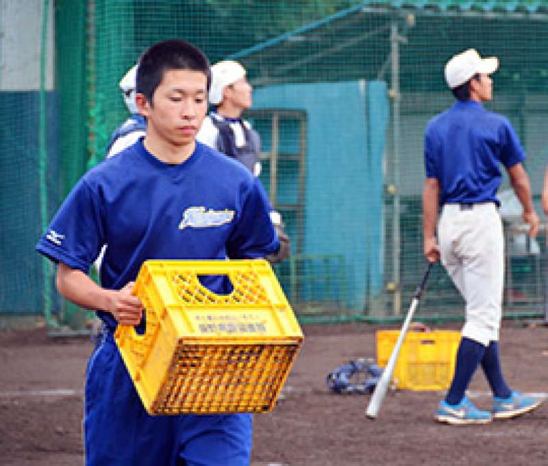守備練習でボールの運搬を手伝う飯塚選手＝千葉市美浜区の検見川高校グラウンド