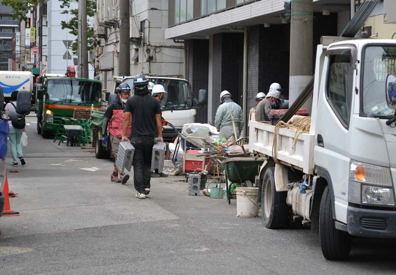 暑い中、マスク姿で作業をする人たち＝１１日午後、千葉市中央区