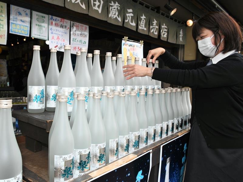 日本酒四季シリーズの最後となる冬吟醸原酒の瓶を並べる門馬店長＝成田市
