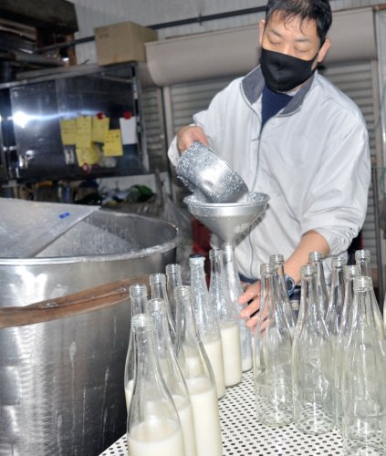 守屋酒造で販売が始まった「どぶろく」の瓶詰め作業＝８日、山武市