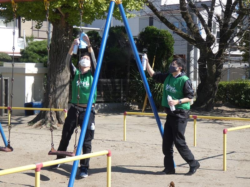 遊具のコーティング作業を行うダイナムの社員＝茂原小
