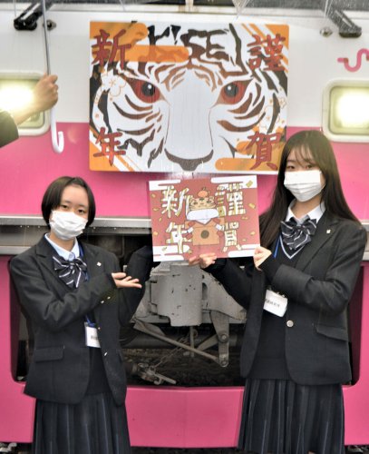 新京成電鉄の正月用ヘッドマークを描いた津田沼高の安藤さん（右）と中山さん＝鎌ケ谷市のくぬぎ山車両基地
