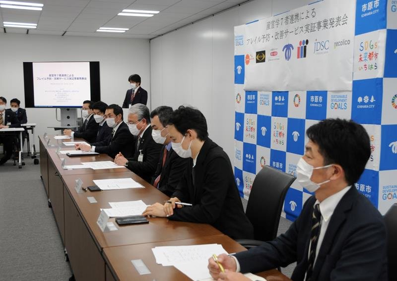 市原市の「フレイル予防・改善サービス実証事業」について説明する産学官７者＝市役所
