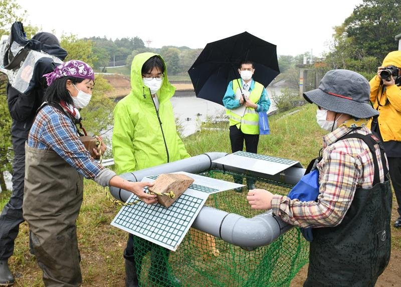 成田空港のＡ滑走路に近くにある調整池に仕掛ける日光浴罠の仕組みを説明する片岡理事長＝２０日
