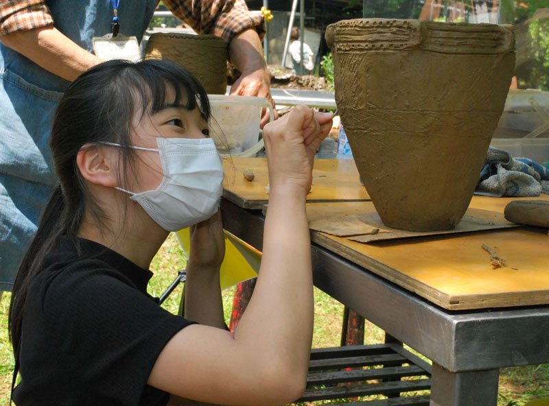 縄文土器の文様付け体験をする来場者＝４日、千葉市若葉区の加曽利貝塚